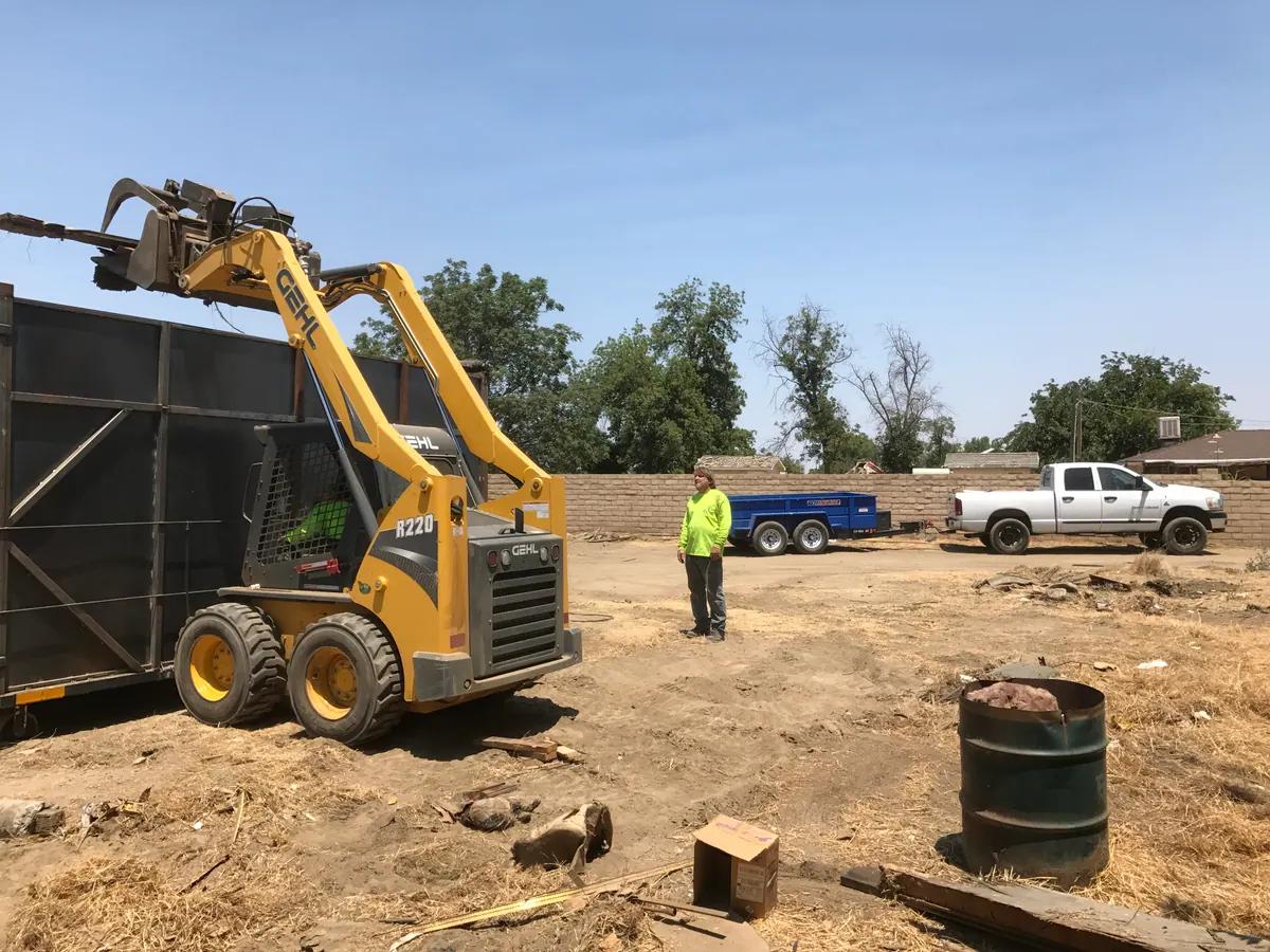 ACH crew and skid steer working a commercial cleanout site