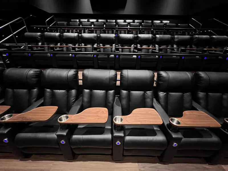 Detail of the cinema recliners with timber tray tables, cup holders and illuminated row numbers