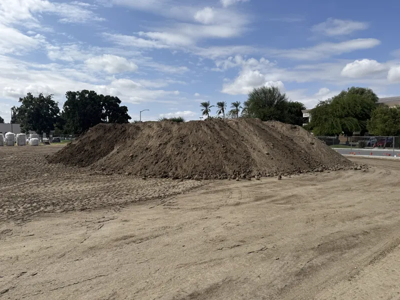 Commercial pad stripped and graded with the spoil stockpiled along the boundary fence