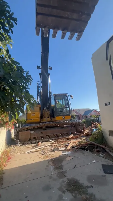 Walkthrough of a back-yard mobile home removal showing the cleared pad, capped utilities and the bin staged for haul-off