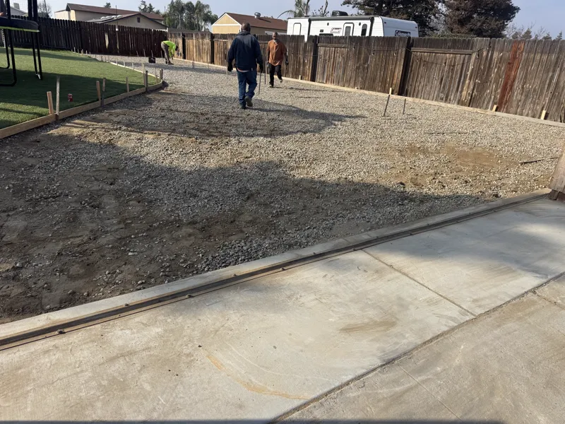 New pad edge formed hard against the existing concrete drive, ready for the pour