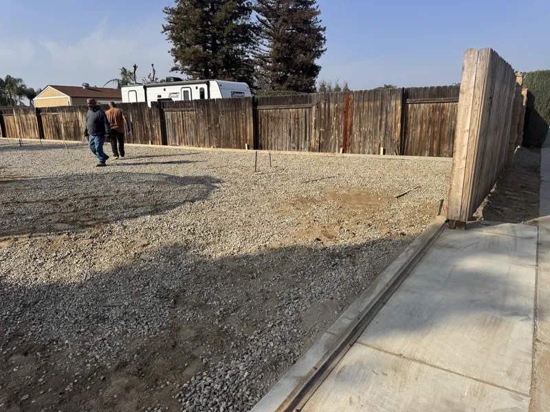 RV pad formed and filled with compacted base rock, tied into the existing drive at the gate