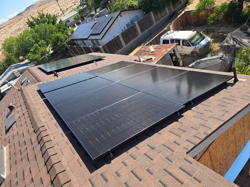 Completed rooftop solar array laid across the main roof plane above the neighborhood