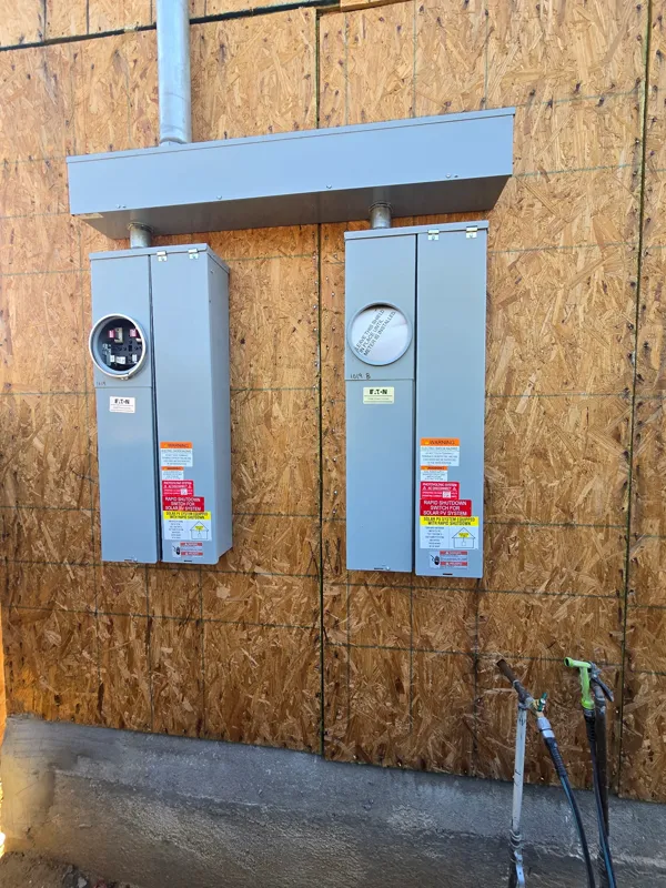 Pair of solar power centers and AC disconnects mounted and labeled on a sheathed equipment wall