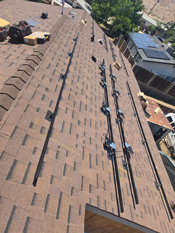 Mounting rails laid out and flashed into a composition shingle roof ahead of the solar panels